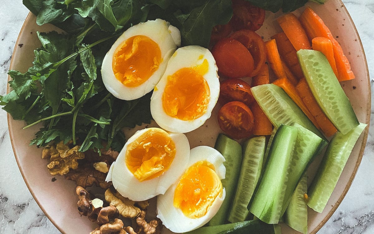 Healthy plate with eggs, greens, tomatoes, and vegetables
